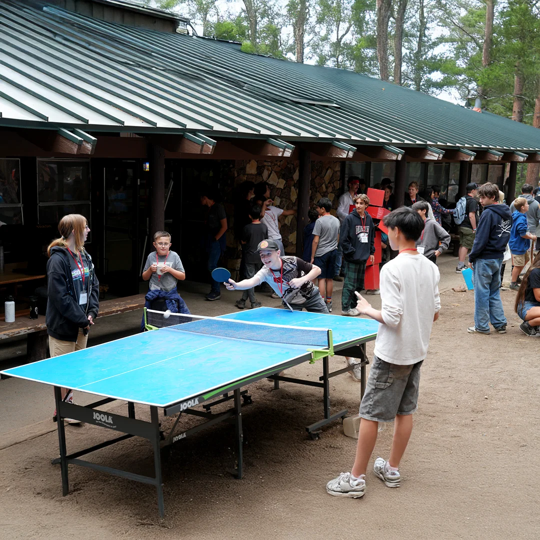 Campers Playing Ping Pong Outdoors